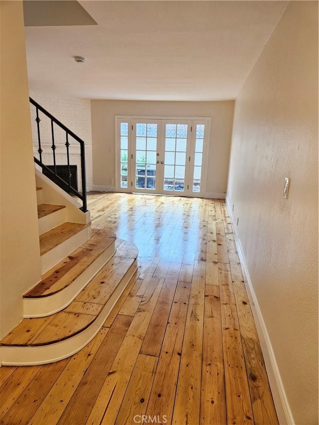 interior space with stairs, baseboards, and wood-type flooring