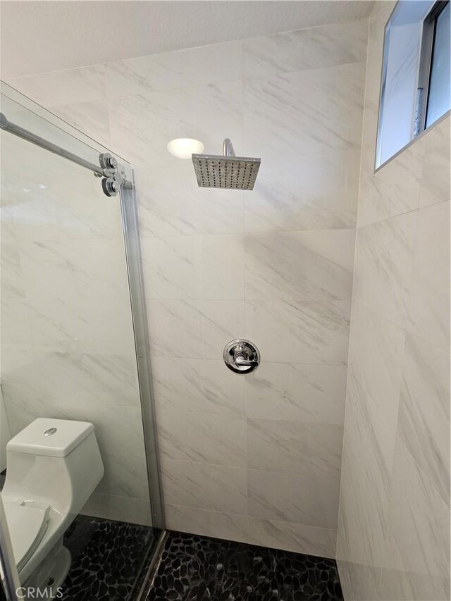 bathroom with toilet and tiled shower