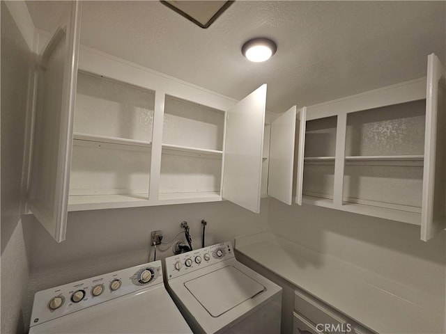 laundry area with cabinet space, washer and dryer, and a textured ceiling