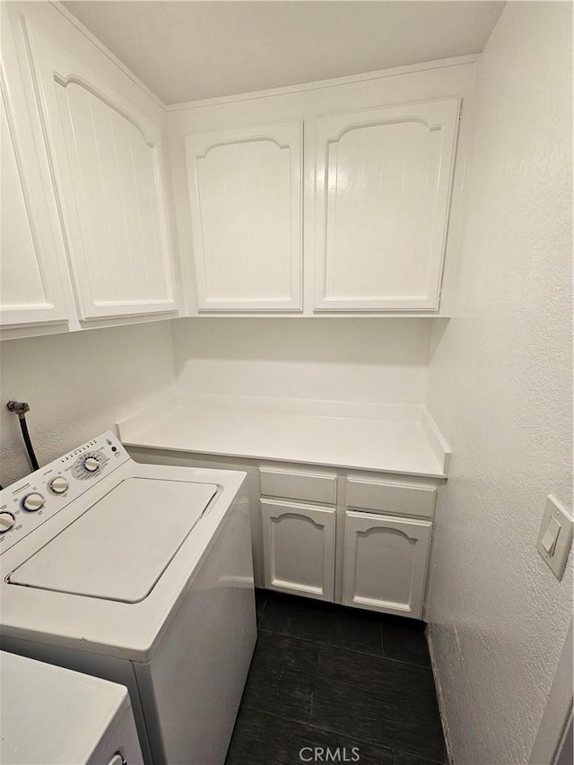 clothes washing area featuring washer / clothes dryer, cabinet space, and dark wood finished floors