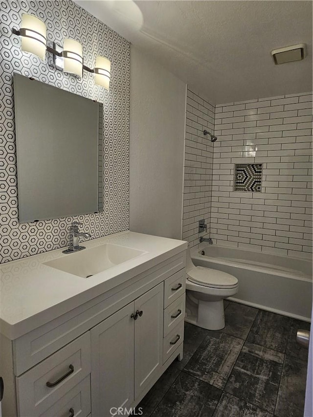 full bathroom with vanity, shower / tub combination, toilet, and a textured ceiling