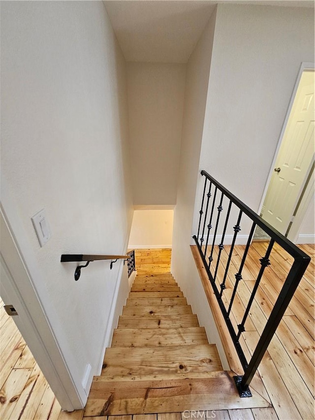 staircase featuring baseboards and hardwood / wood-style floors