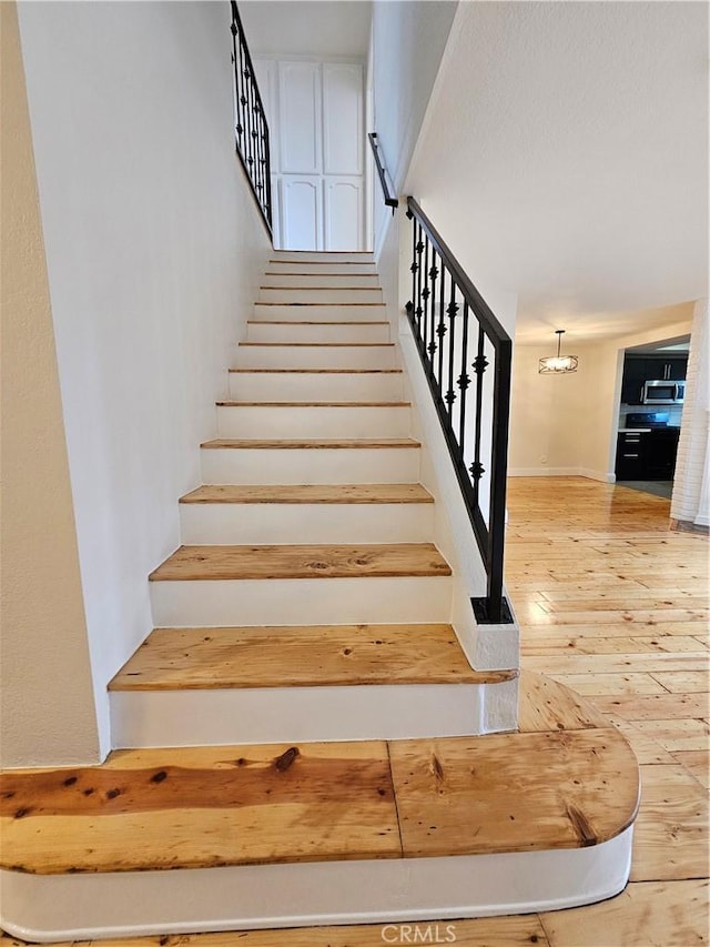 staircase with hardwood / wood-style floors