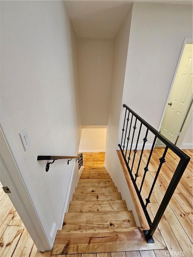 staircase with hardwood / wood-style floors and baseboards