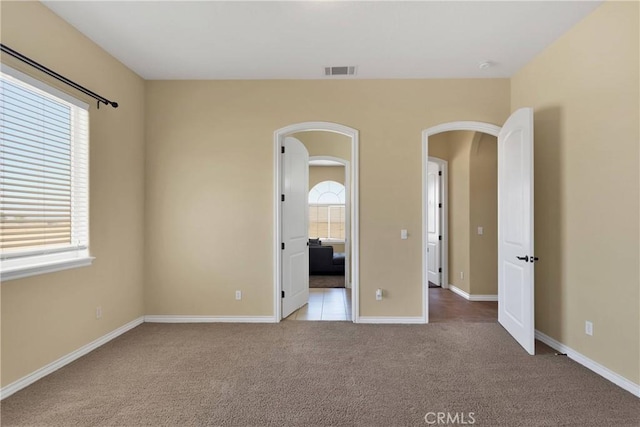 unfurnished bedroom with multiple windows and light colored carpet