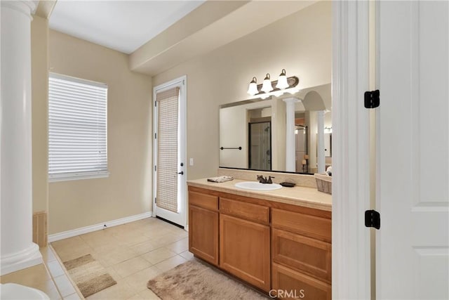 bathroom with decorative columns, vanity, a shower with door, and tile patterned floors