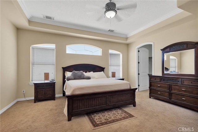 carpeted bedroom featuring ornamental molding, ceiling fan, and a tray ceiling