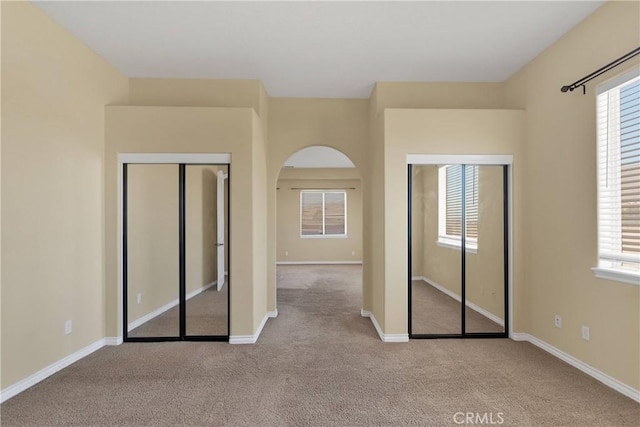 unfurnished bedroom featuring light colored carpet and a closet