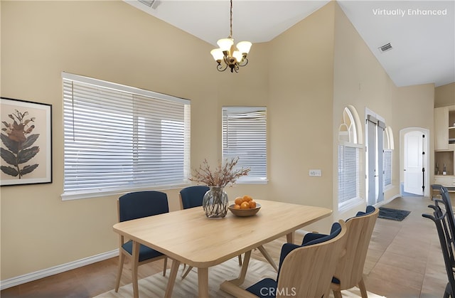 tiled dining room with a chandelier