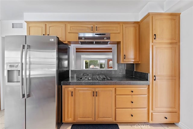 kitchen featuring light brown cabinets, light tile patterned floors, stainless steel appliances, and tasteful backsplash