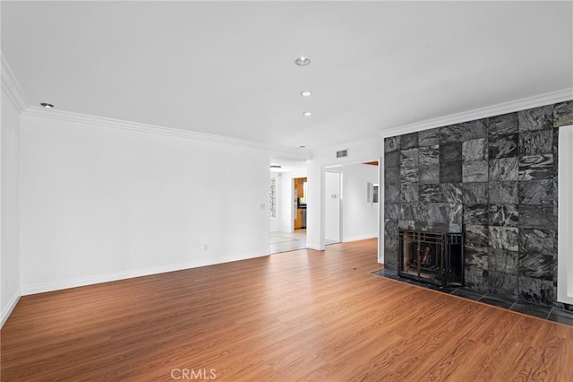 unfurnished living room with hardwood / wood-style floors, crown molding, and a fireplace