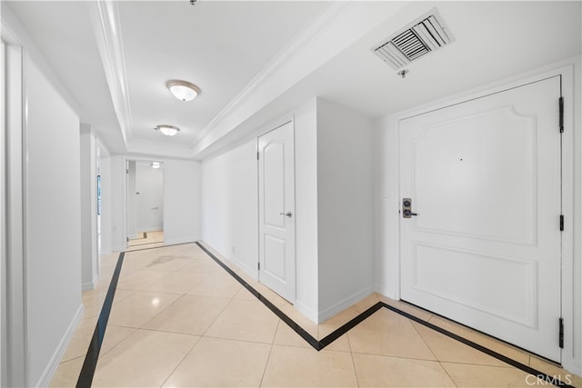 tiled foyer featuring crown molding