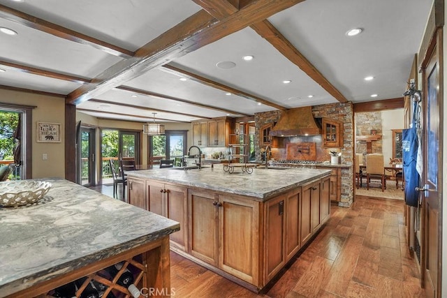 29130 Bald Eagle Rdg, Lake Arrowhead, CA 92352 - kitchen featuring light stone countertops, beamed ceiling, a large island with sink, custom range hood, and hardwood / wood-style flooring