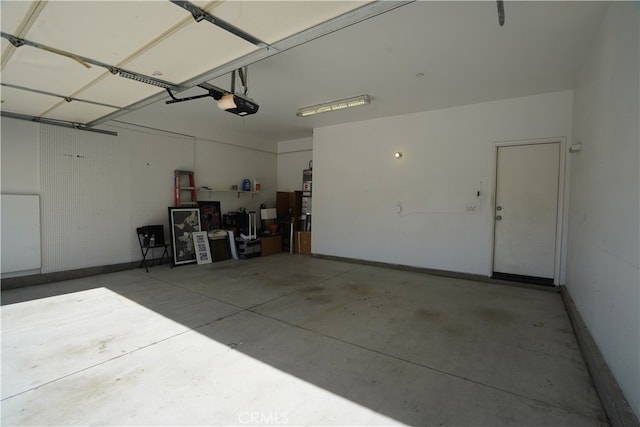 garage with baseboards and a garage door opener