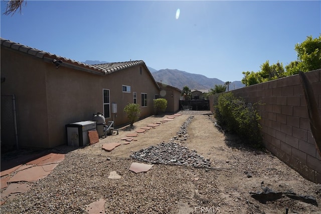 view of yard with a fenced backyard and a mountain view