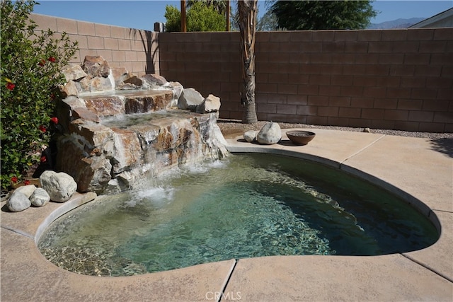 view of pool featuring a fenced backyard and a jacuzzi