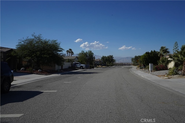 view of street with curbs, sidewalks, and a mountain view