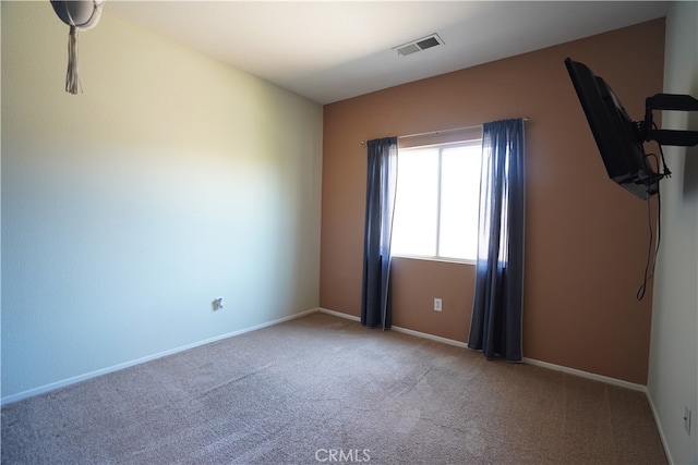 carpeted empty room featuring visible vents and baseboards