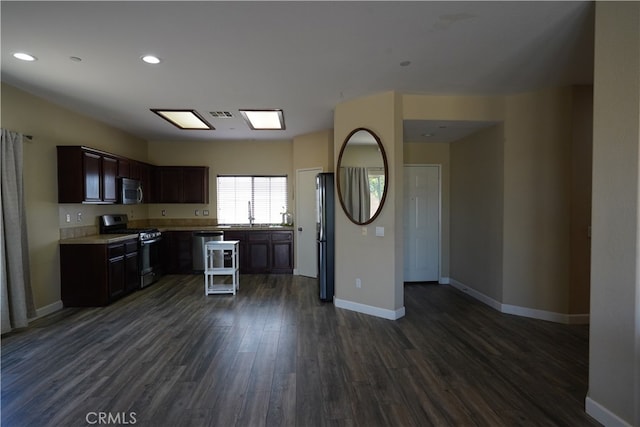 kitchen with stainless steel appliances, dark wood-style flooring, light countertops, and baseboards