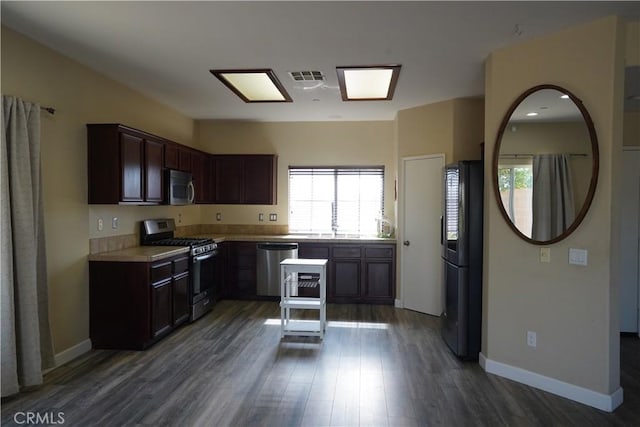 kitchen with visible vents, dark wood-style flooring, stainless steel appliances, dark brown cabinets, and light countertops