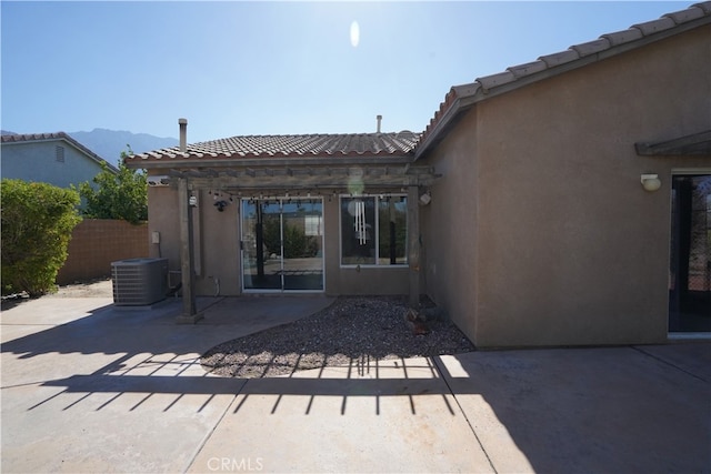 back of house featuring a patio, stucco siding, central AC, fence, and a tiled roof