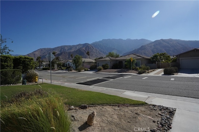 view of street featuring traffic signs, a mountain view, and sidewalks