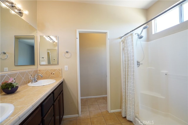 bathroom with tile patterned flooring, a shower with shower curtain, a sink, decorative backsplash, and double vanity