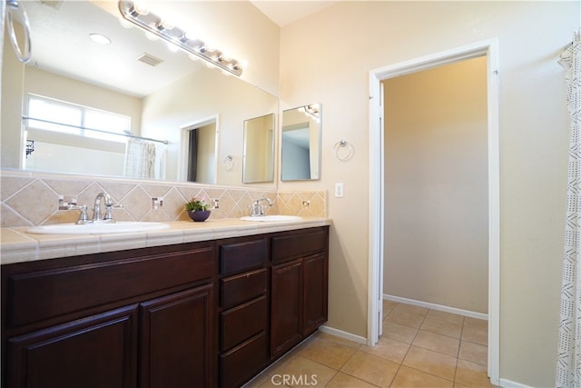 bathroom featuring tasteful backsplash, tile patterned flooring, visible vents, and a sink