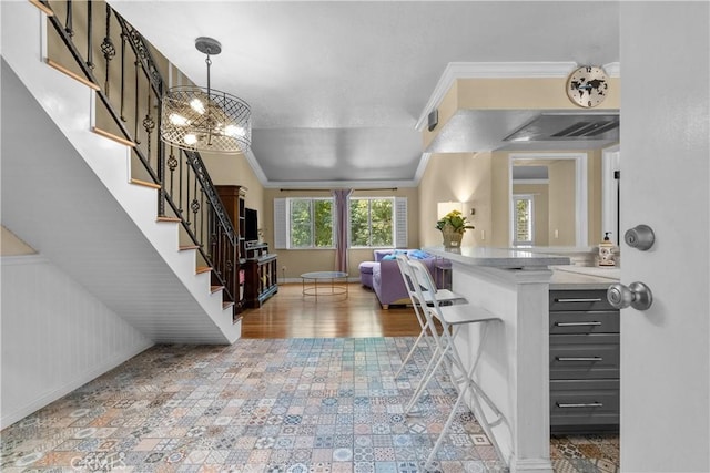 foyer entrance featuring crown molding, wooden walls, a notable chandelier, and hardwood / wood-style flooring