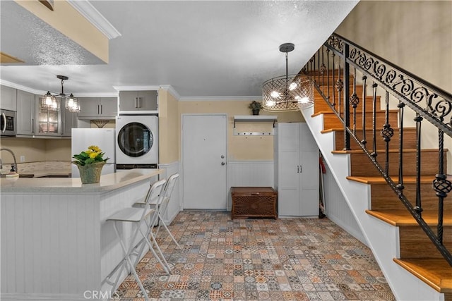 kitchen featuring white refrigerator, gray cabinets, hanging light fixtures, and ornamental molding