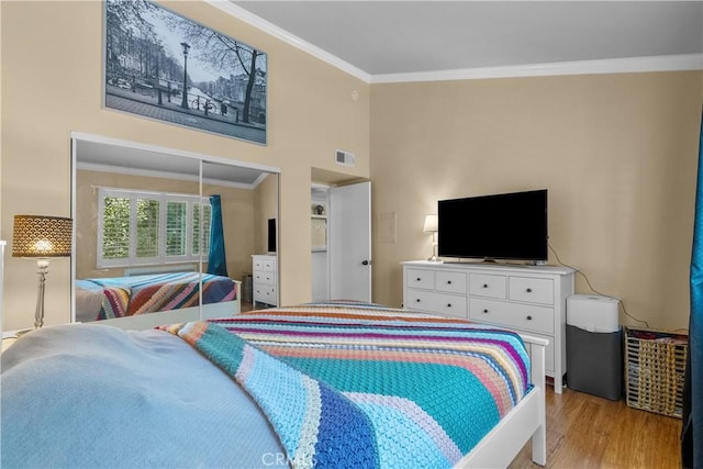 bedroom featuring crown molding and light hardwood / wood-style flooring