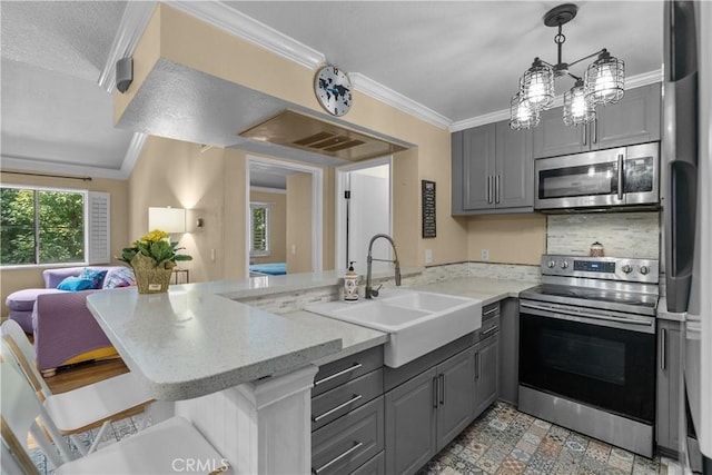 kitchen featuring gray cabinetry, sink, stainless steel appliances, light stone counters, and kitchen peninsula