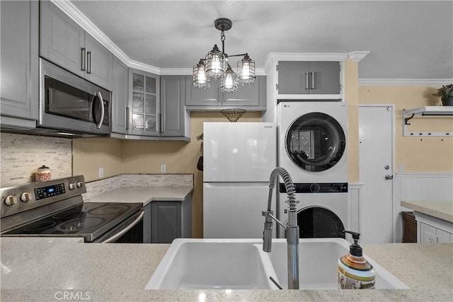 kitchen with gray cabinetry, sink, decorative light fixtures, appliances with stainless steel finishes, and ornamental molding