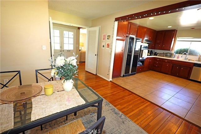 622 E Lomita Ave, Orange, CA 92867 - kitchen featuring freestanding refrigerator, light wood-style floors, dishwasher, reddish brown cabinets, and light countertops