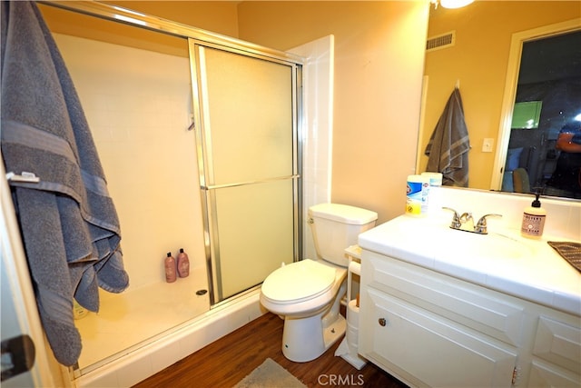 bathroom with vanity, hardwood / wood-style floors, toilet, and an enclosed shower