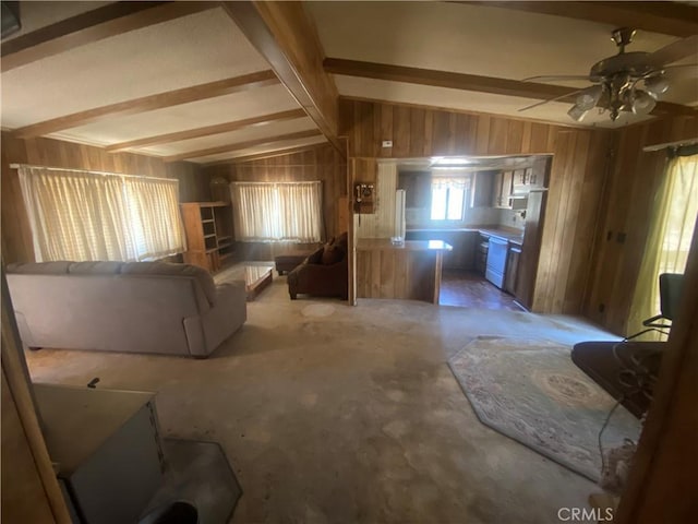 living room with ceiling fan, wooden walls, and lofted ceiling with beams