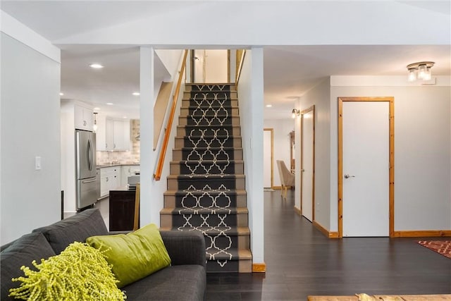 stairway with recessed lighting, baseboards, vaulted ceiling, and wood finished floors