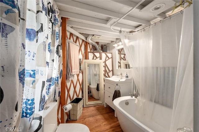 bathroom with wood finished floors, toilet, vanity, and shower / bathtub combination with curtain