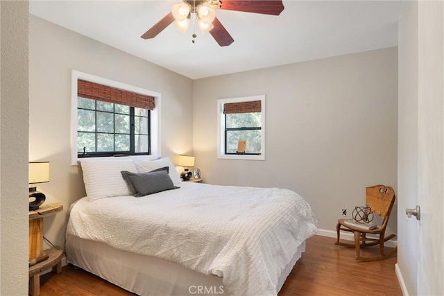 bedroom with baseboards, wood finished floors, and a ceiling fan