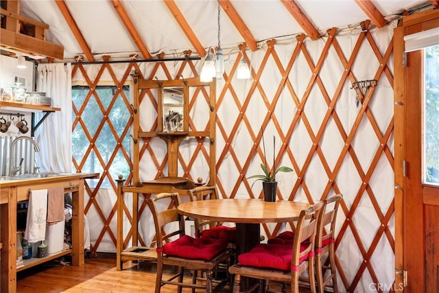 interior space featuring vaulted ceiling with beams, sink, hardwood / wood-style floors, and an inviting chandelier