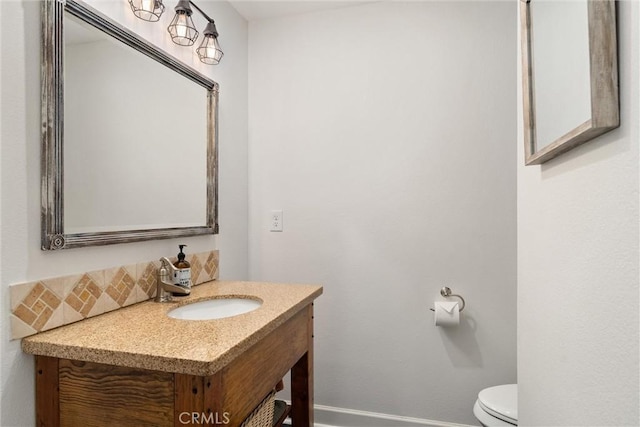 bathroom featuring baseboards, decorative backsplash, toilet, and vanity