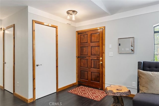 foyer featuring baseboards and wood finished floors
