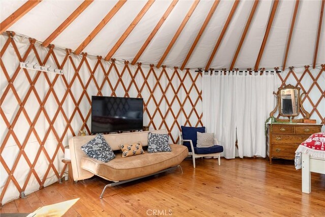 living room with hardwood / wood-style flooring and vaulted ceiling with beams