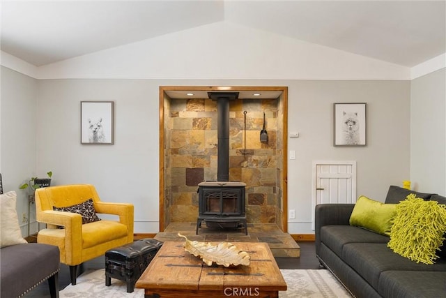 living room with lofted ceiling, wood finished floors, and a wood stove