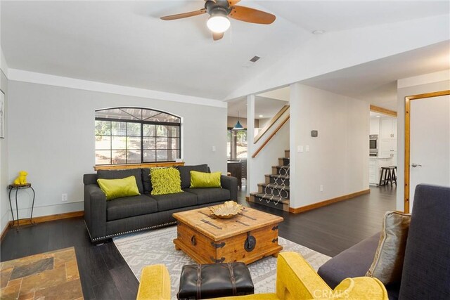 living room featuring dark hardwood / wood-style floors, vaulted ceiling, and ceiling fan