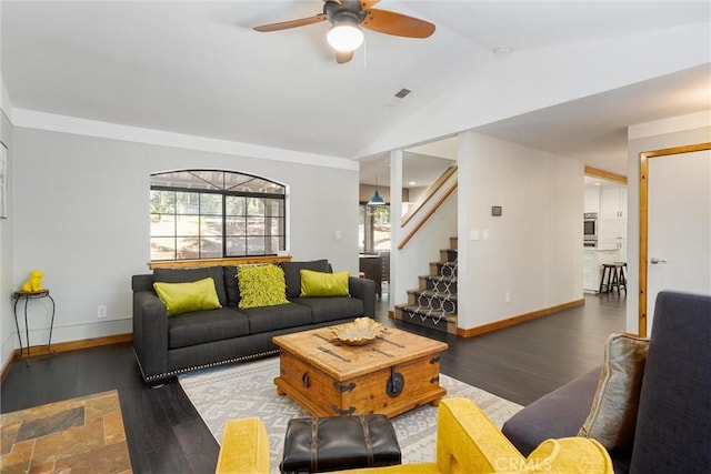 living room featuring visible vents, wood finished floors, stairway, a ceiling fan, and lofted ceiling