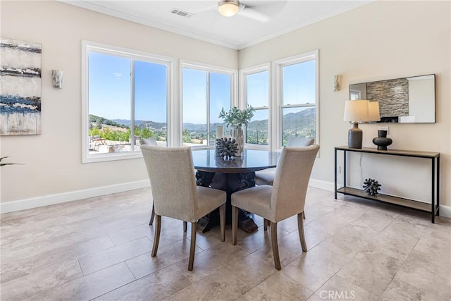 dining area featuring a mountain view, crown molding, ceiling fan, and a healthy amount of sunlight