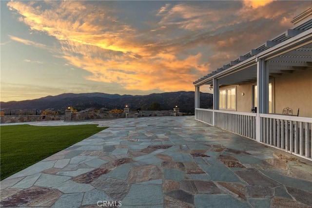 patio terrace at dusk with a lawn and a mountain view