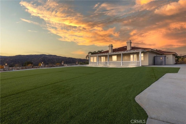 exterior space featuring a mountain view, a patio, and a lawn