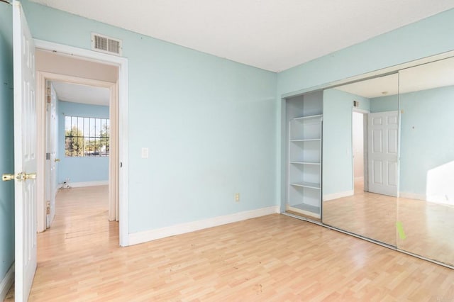 unfurnished bedroom featuring a closet and light hardwood / wood-style flooring